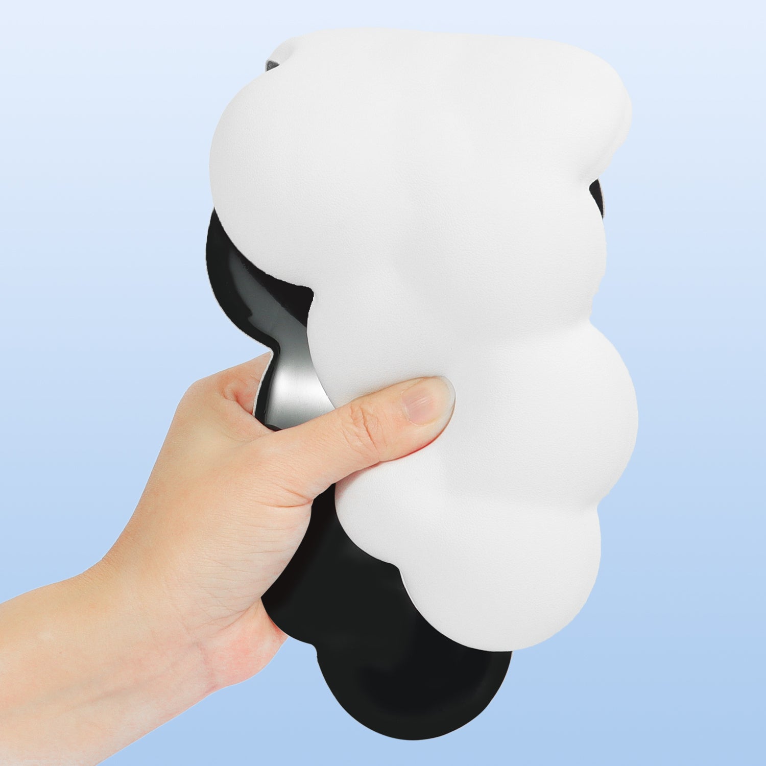 Hand holding a cloud-shaped ergonomic wrist rest in white.