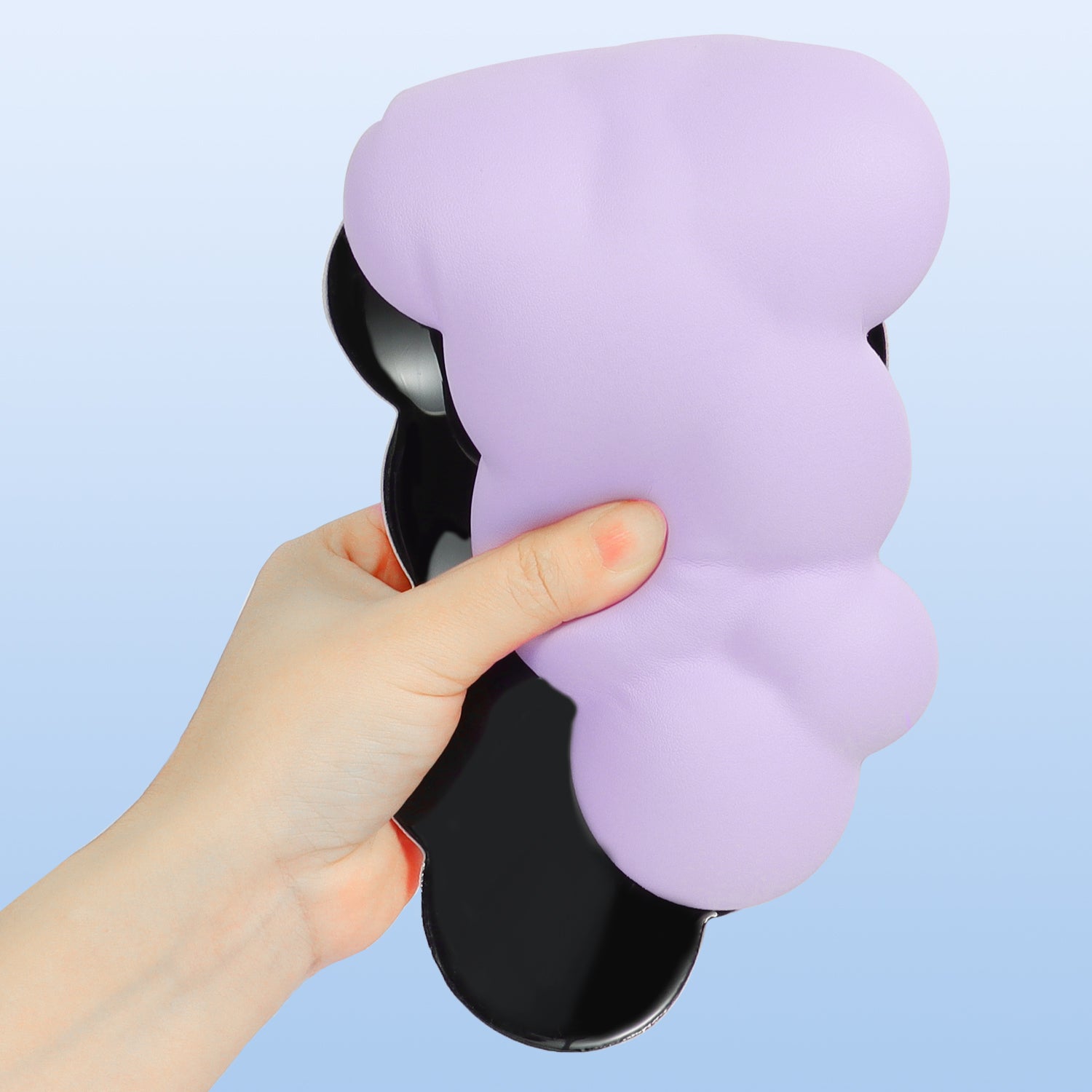 Hand holding lavender cloud-shaped ergonomic wrist rest with anti-slip base.